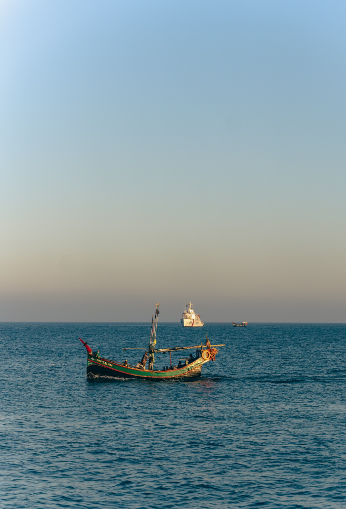 A small colorful fishing boat on a calm blue sea